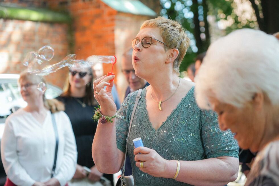 Freunde lachen gemeinsam bei Hochzeit in Lübeck