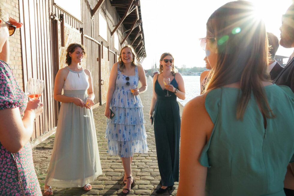 Freunde lachen gemeinsam bei Hochzeit in Lübeck